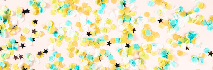 Festive panorama with confetti. Carnival greeting card with golden stars on a pink background