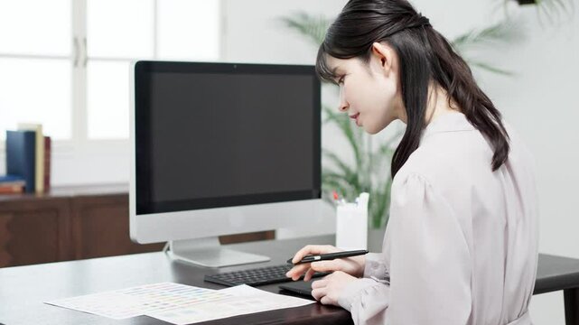 パソコンで仕事をするクリエイターの女性