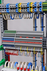 Electrical screw through terminals with connected insulated wires in an electrical switchboard.