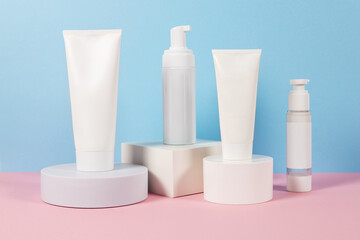 Beautiful cosmetic templates for ads, plastic cream tubes and bottles on a blue background with...
