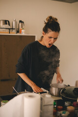 Dirty electrical induction stove after cooking, milk run out, woman wash stove with paper towel,...