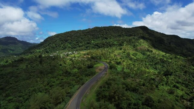 Aerial top down view of car driving through tropical jungle green rainforest, exotic wilderness landscape of FIji Island. Travel tourism concept. Drone shot of thick brazil Fiji forest. Wild place