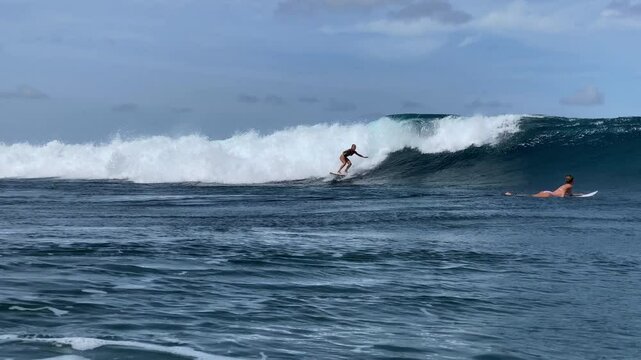 Female surfer on a blue ocean wave, Banyak islands, Indonesia 