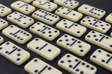 Classic domino tiles on black background, flat lay. Space for text