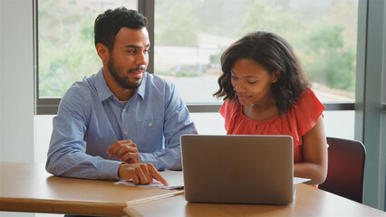 Male And Female High School College Or University Tutors Having Planning Meeting In Classroom