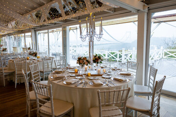 Elegant Indoor Table Setting with White Tablecloths and Floral Centerpieces