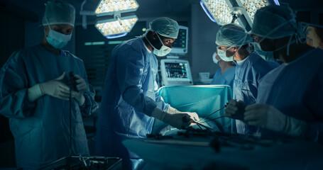 Portrait of a Surgical Team Conducting an Operation in a Dark Hospital Room with Technological...