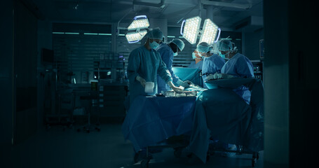 Medical Team Performing a Complex Surgery on a Patient, Using Specialized Tools, Looking at Digital Screens with Health Information. Doctors with a Female Surgeon in the Lead Saving Patient's Life