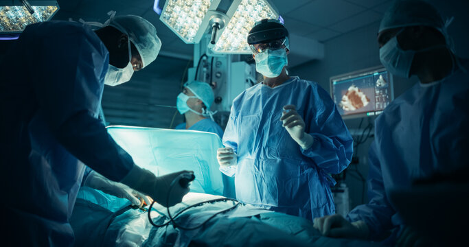 Operating Team Following Directions of a Female Surgeon Using Augmented Reality Headset, Where a Digital Overlay Helping to Streamline the Process During a Medical Operation with a Patient