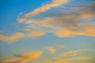 Landscape of a blue sky at sunset with clouds gilded by the sun