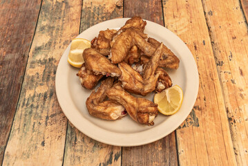 A nice helping of fried chicken wings with a little lemon