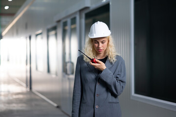 Radio walkie talkie. Caucasian business woman worker in safety hard hat helmet using walkie-talkie at warehouse factory. communication radio. supply chain and delivery. Insustry inventory warehouse