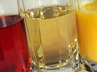 Apple, orange and grape juice in transparent glasses