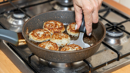 Meat burgers or cutlet-shaped patty being shallow fried in oil on a frying pan, close up. version of cutlets - kotlety.