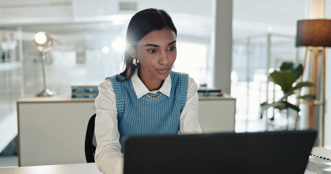 Accounting, laptop and reading with business Indian woman at desk in office for bookkeeping report. Computer, information and research with junior accountant in workplace for financial management