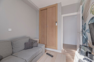 Small room in a house with a custom-made built-in wardrobe and sofas fitted into the space