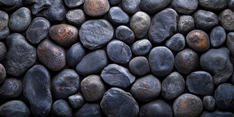 Smooth and dark stones create a captivating stone background wall, featuring an arrangement of round stones that enhance the overall texture and aesthetic appeal of the stone background.