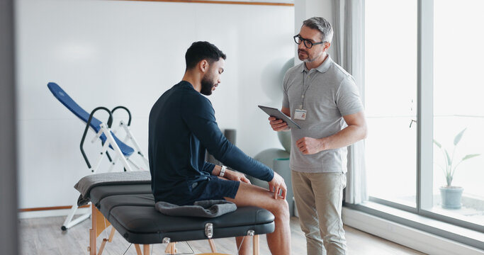 Physiotherapy, tablet and knee pain with man and athlete in clinic for rehabilitation, healthcare or consulting. Support, medical and chiropractor with people for healing, advice or physical therapy