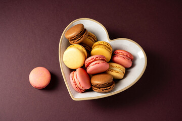 Macarons colorful cookies in heart shaped bowl. Sweet dessert