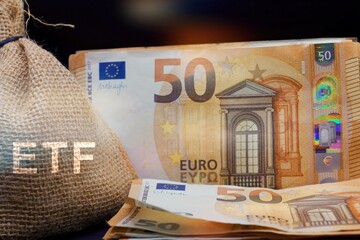 ETF (Exchange Traded Fund) word in a rough burlap sack with euro banknotes on a table. Business...