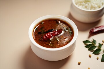 Tomato rasam served with rice, selective focus