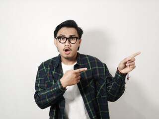 Adult Asian man showing shocked expression with both hands pointing to the left side