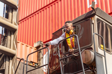 forklift driver working at shipping container,holding walkie talkie point index to communicate with foreman control loading