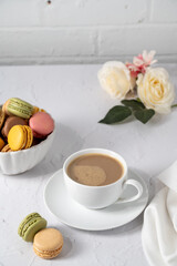 Macarons colorful cookies with cup of coffee, stack of french macarons in a plate. Sweet dessert