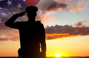 Silhouette of a police officer against the sunset. American flag against the sunset. National Law...