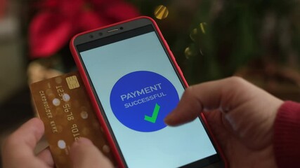 Hands holding smartphone and credit card to pay for Christmas shopping online