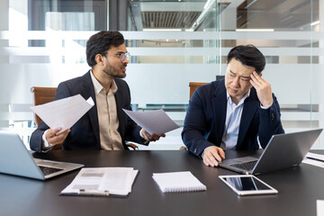 Two business professionals in a meeting, as one expresses dissatisfaction over a financial report....