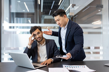 A frustrated employee is scolded by his boss during a tense office meeting. The interaction...