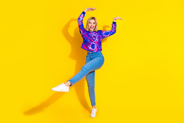 Full size photo of pretty young girl dancing have fun wear trendy colorful blue outfit isolated on yellow color background