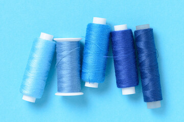 Blue thread spools background with copy space for text close-up flat lay top view