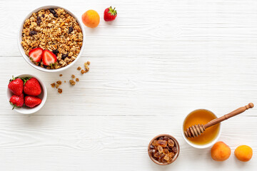 Two bowls of cereal granola with strawberry and honey for breakfast, top view