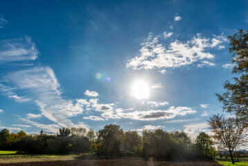 Panorama des leicht bewölkten, blauen Himmels mit Horizont und Sonnenscheibe