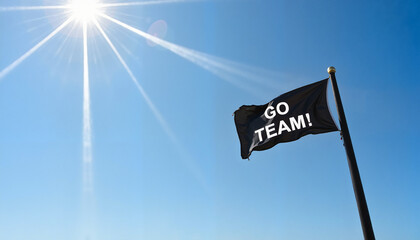 Cheering "Go Team!" flag waving under bright sun against clear blue sky for motivation and support