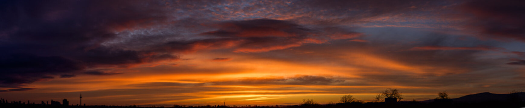Stimmungsvoller Sonnenauf- oder Sonnenuntergang mit orange verf&auml;rbten Wolken am Horizont