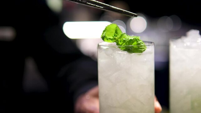 Gin Cocktail with peach pulp, oleo saccharum, maraschino syrup, elderflower belvoir and albahaca garnish in a on the rocks glass