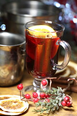 Mulled wine with cranberries, orange and cinnamon on a wooden table