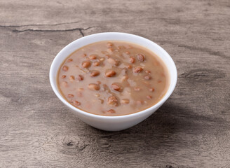 Cooked brown beans in a bowl over wooden table