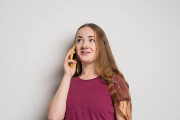 Young beautiful girl uses modern smartphone at home