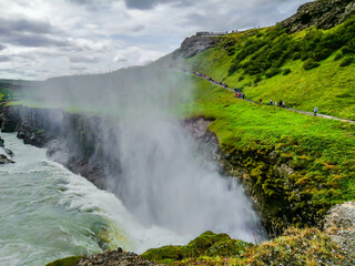 Panoramic view of Gullfoss falls and tourists walking by