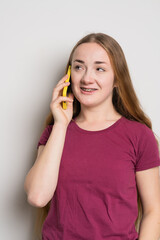 Young beautiful girl uses modern smartphone at home