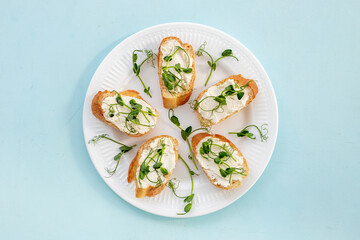 Plate of sandwiches with cream cheese and micro greens peas. Healthy food, top view