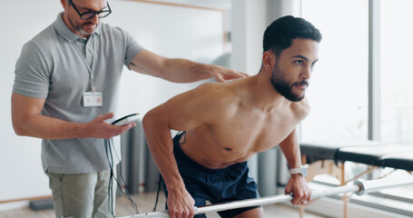 Physiotherapy, consulting and monitor with man in clinic for biofeedback, muscle stimulation and...