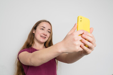 Young beautiful girl uses modern smartphone at home