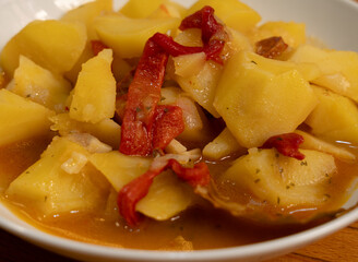 Closeup of a dish with traditional spanish food. Potatoes with red pepper and chorizo. Spain, Rioja.