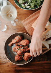 Grabbing Chicken Wings and Legs on a Plate at a Restaurant