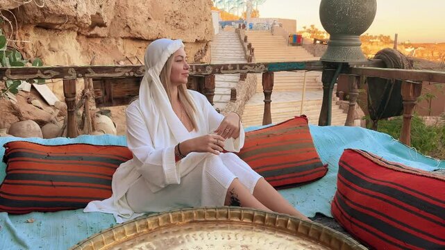 A beautiful girl in traditional clothes rests in a cafe in Egypt